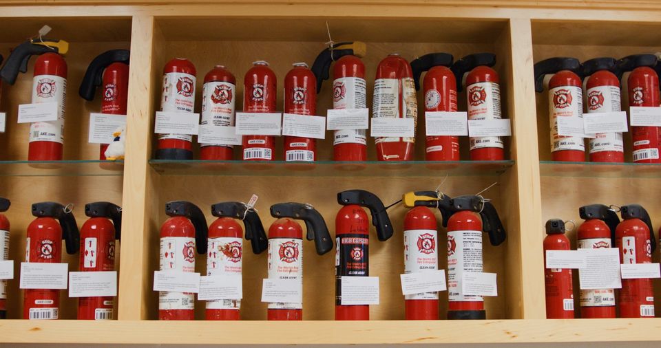 STOP-FYRE fire extinguishers sitting on a shelf in AKE Safety Equipment headquarters